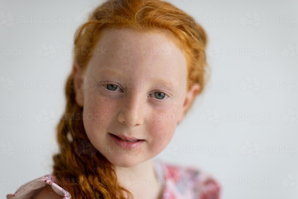 close cropped portrait of freckled child with ginger hair - Australian Stock Image