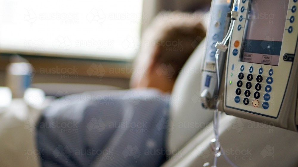 Close of hospital drip machine with patient in background - Australian Stock Image