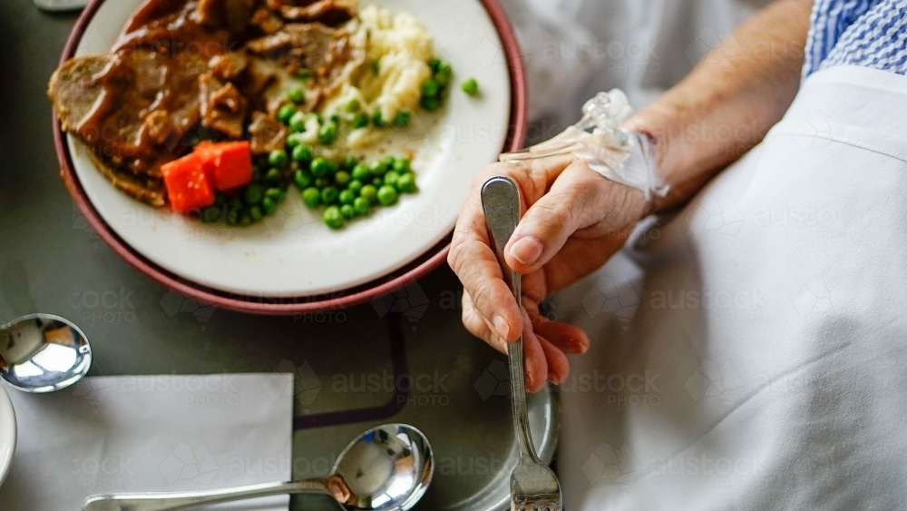 Close of up hand and dinner plate - Australian Stock Image