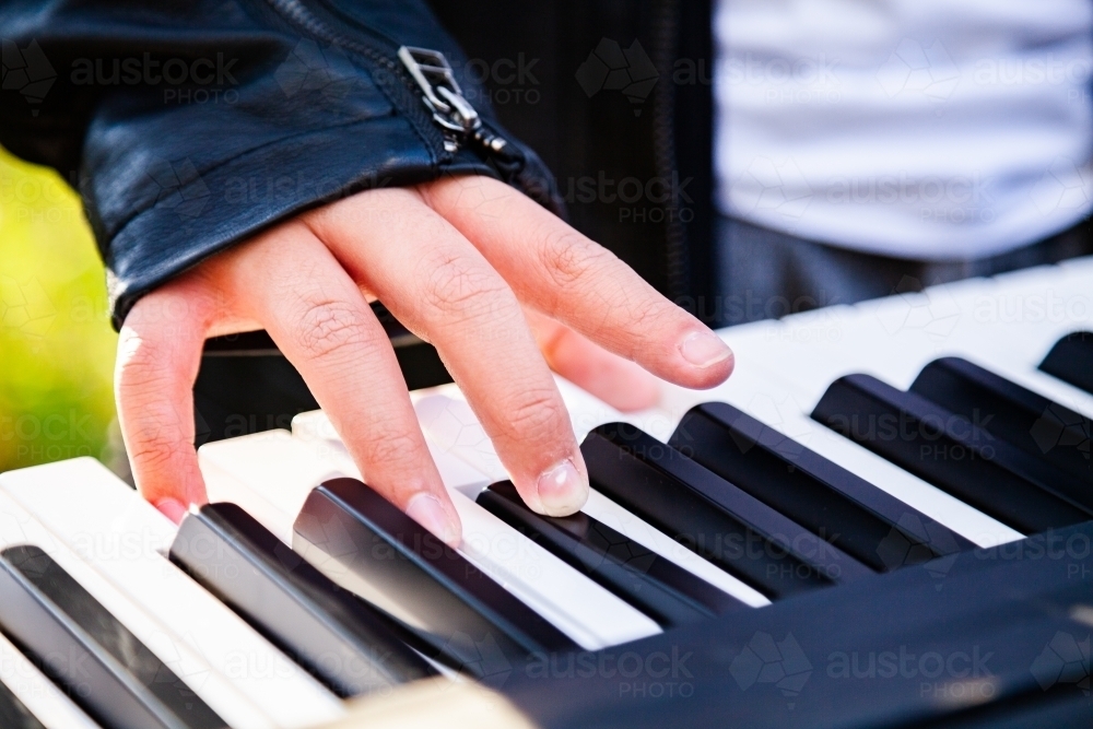 Close up detail of boy playing keyboard keys - Australian Stock Image