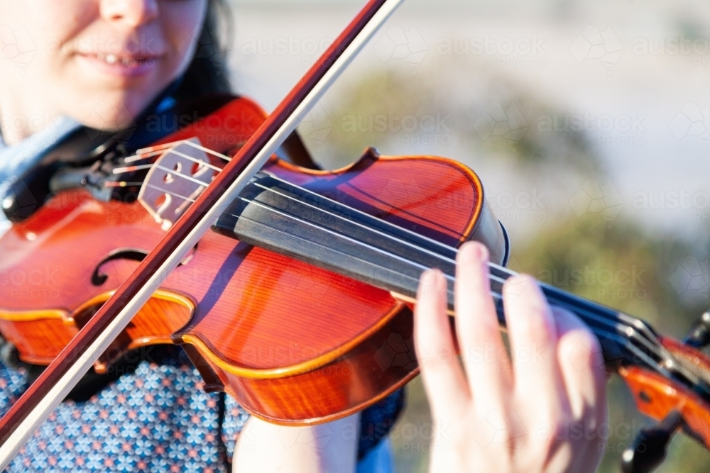 Close up detail of girl playing violin outside - Australian Stock Image