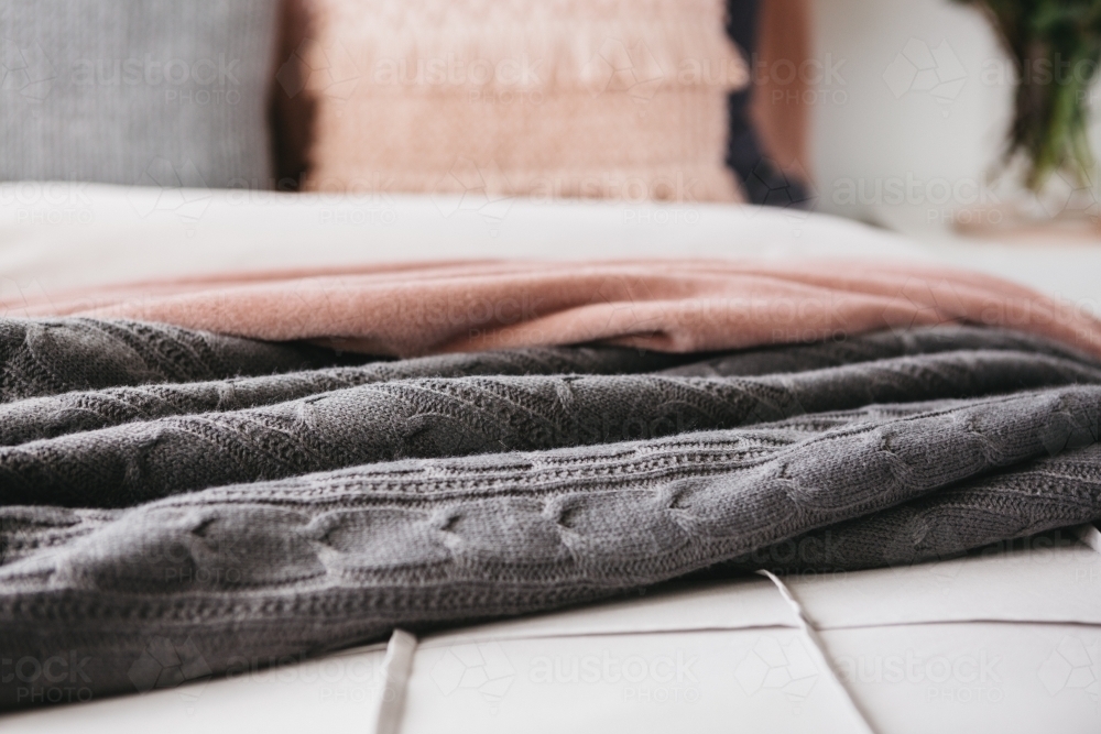 Close up detail of grey and pink throw rugs horizontal - Australian Stock Image