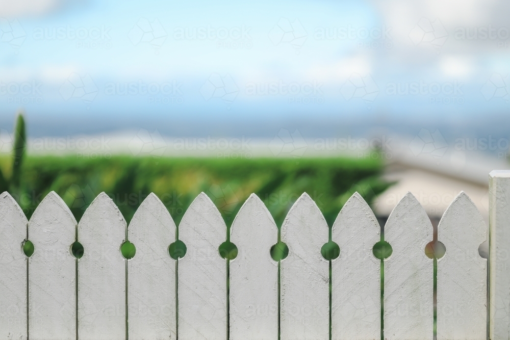 Close up image of white picket fence with beach background - Australian Stock Image
