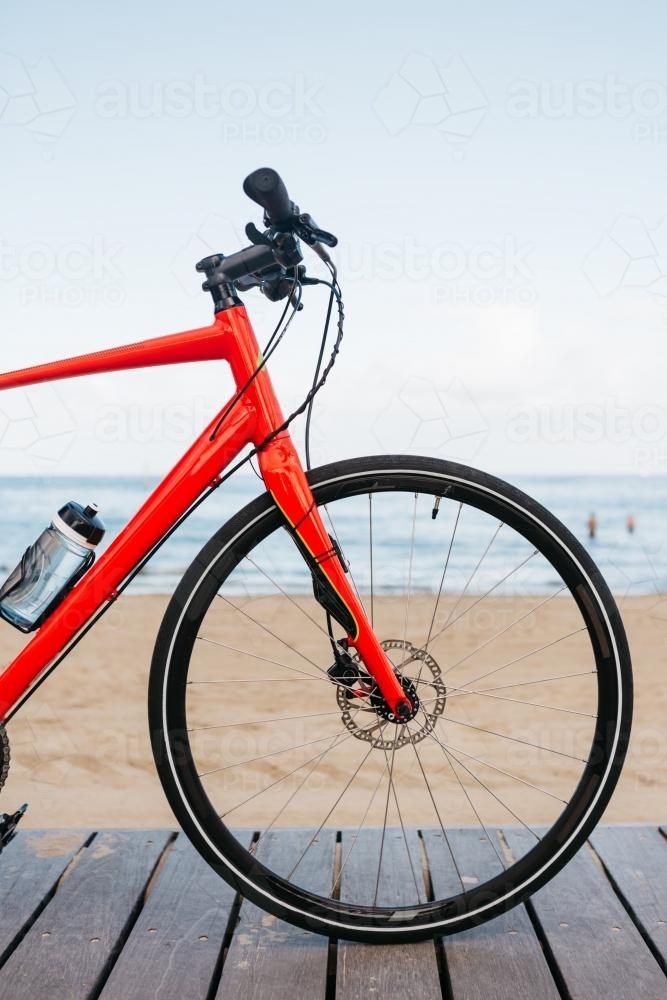 Close up of a bicycle wheel with beach in the background - Australian Stock Image