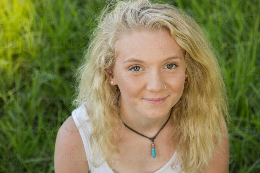 Close up of a blonde teen smiling outside - Australian Stock Image