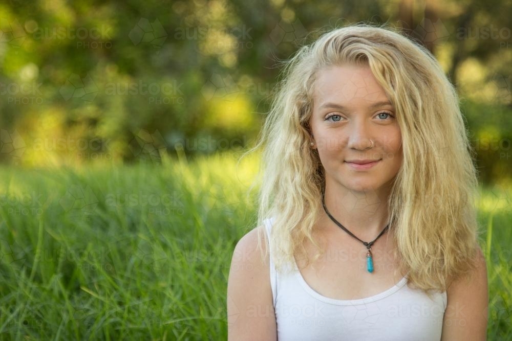 Close up of a blonde teen smiling outside - Australian Stock Image