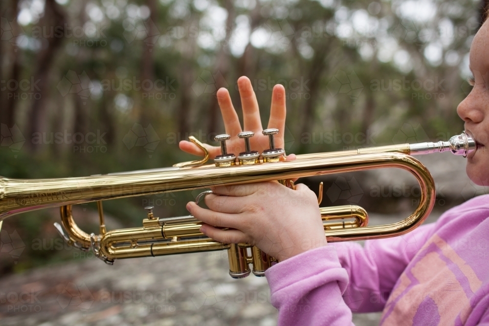 Image of Close up of a girl playing a trumpet Austockphoto