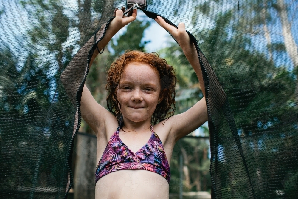 Close up of a girl standing on a trampoline in a bikini - Australian Stock Image