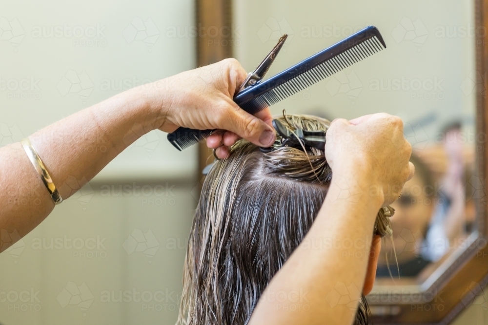 Image of Close up of a hairdresser clipping a ladies hair into position