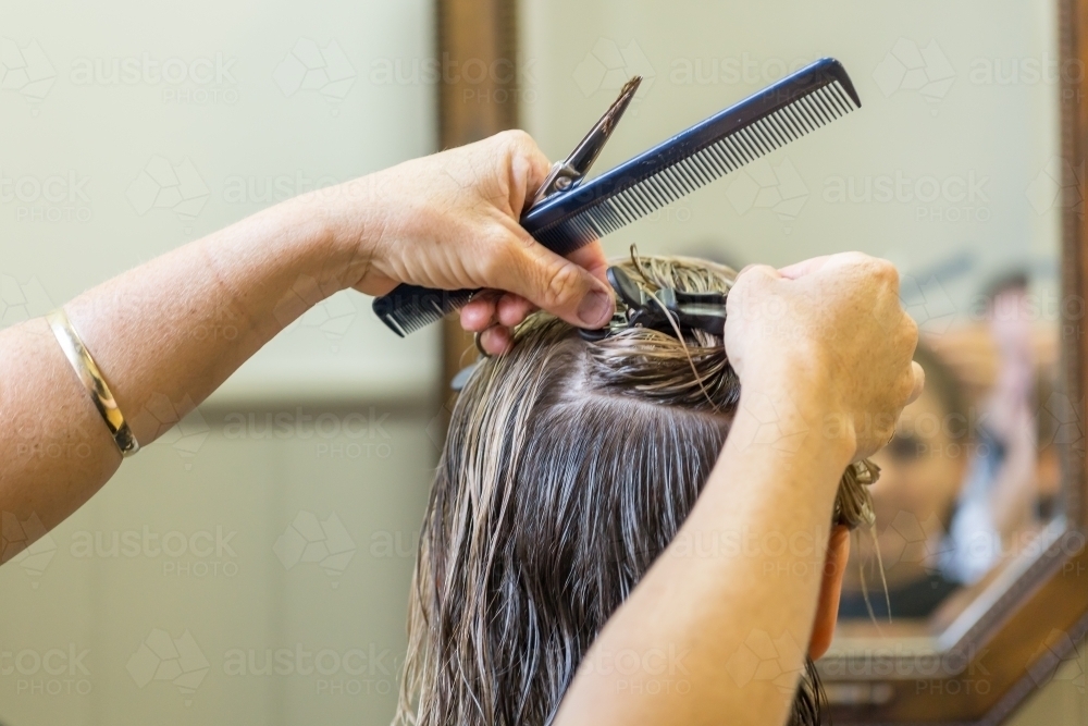 Close up of a hairdresser clipping a ladies hair into position - Australian Stock Image