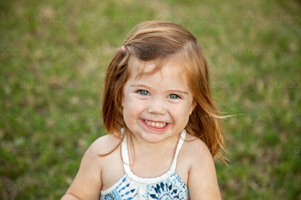 Close up of a happy little girl grinning - Australian Stock Image