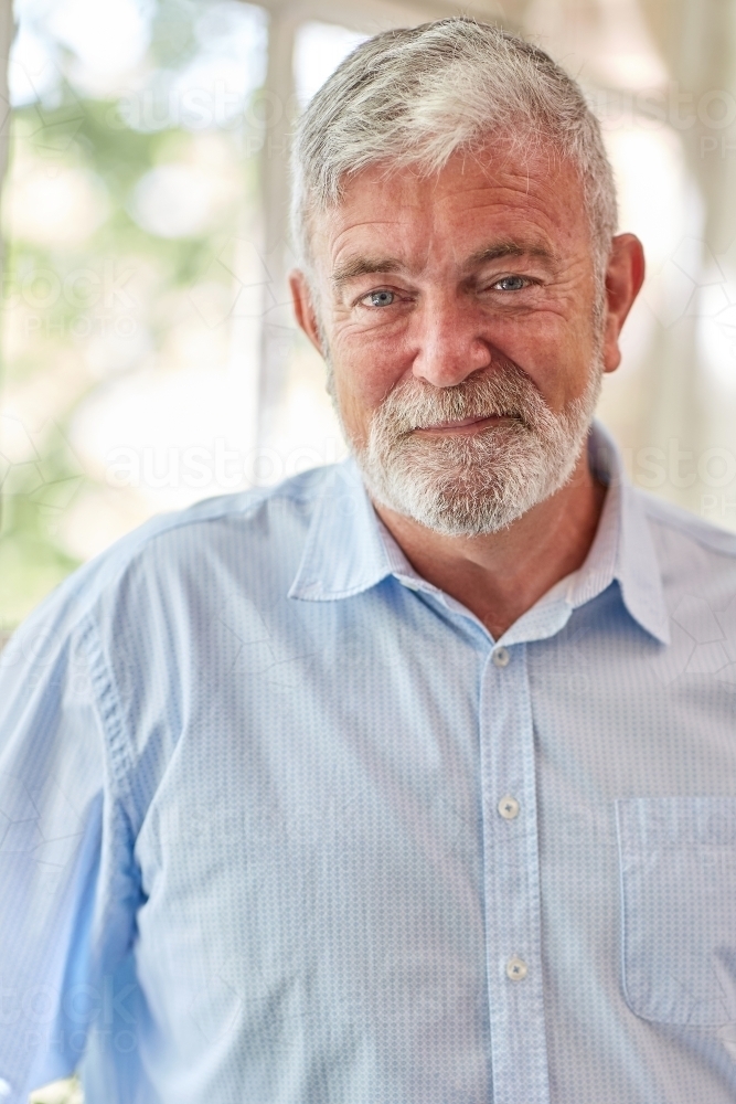 Close-up of a mature businessman standing near a paned window - Australian Stock Image
