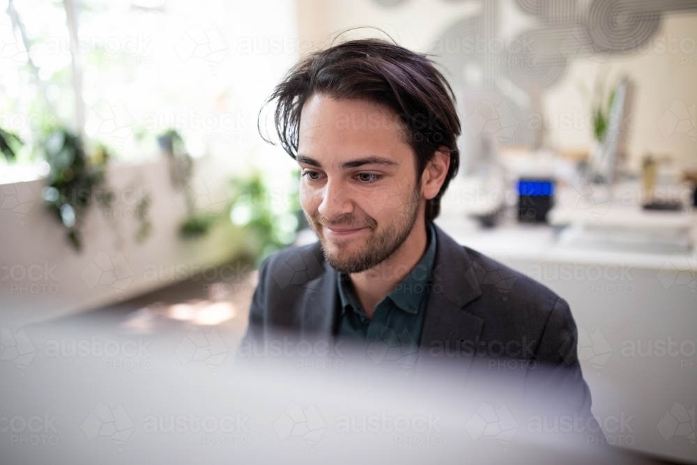 Image of Close-up of a smiling business man working on a computer ...