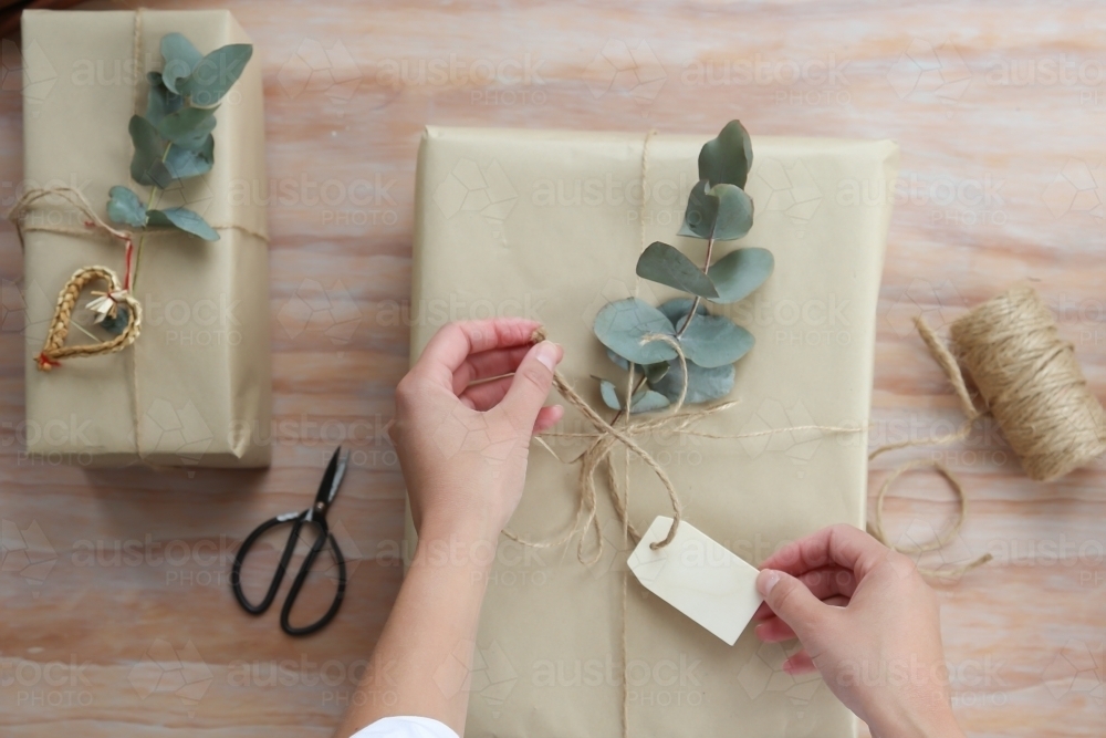 Close up of a womans' hands wrapping present - Australian Stock Image