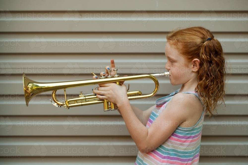 Close up of a young girl playing a trumpet - Australian Stock Image