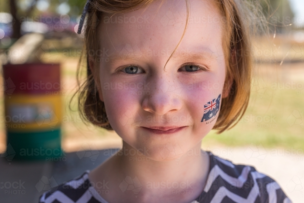 Close up of a young girl smiling with an australian flag tattoo on her cheek - Australian Stock Image