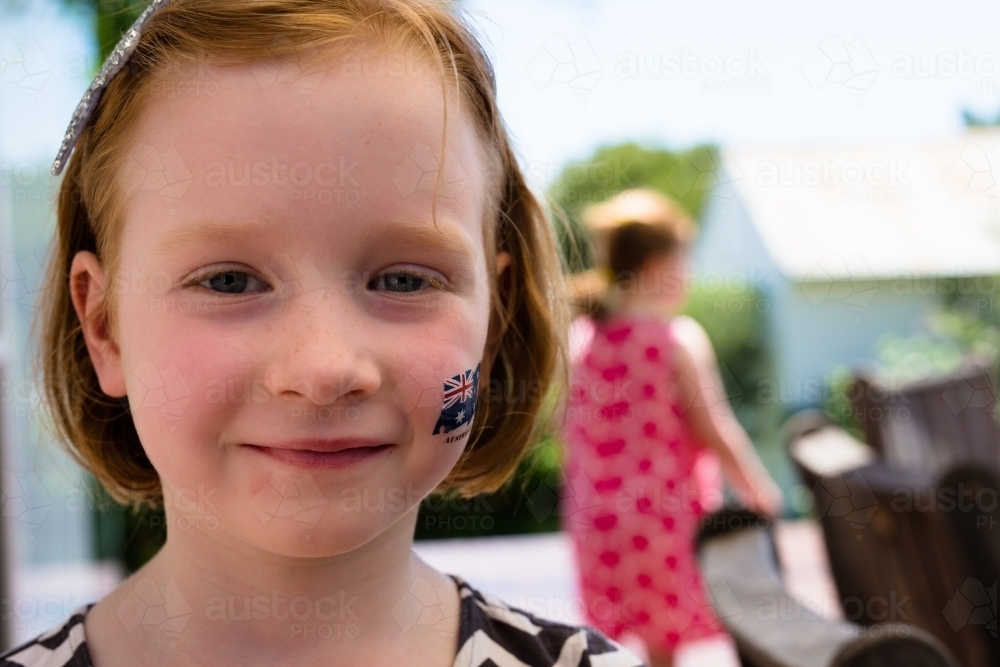 Close up of a young girl smiling with an australian flag tattoo on her cheek - Australian Stock Image
