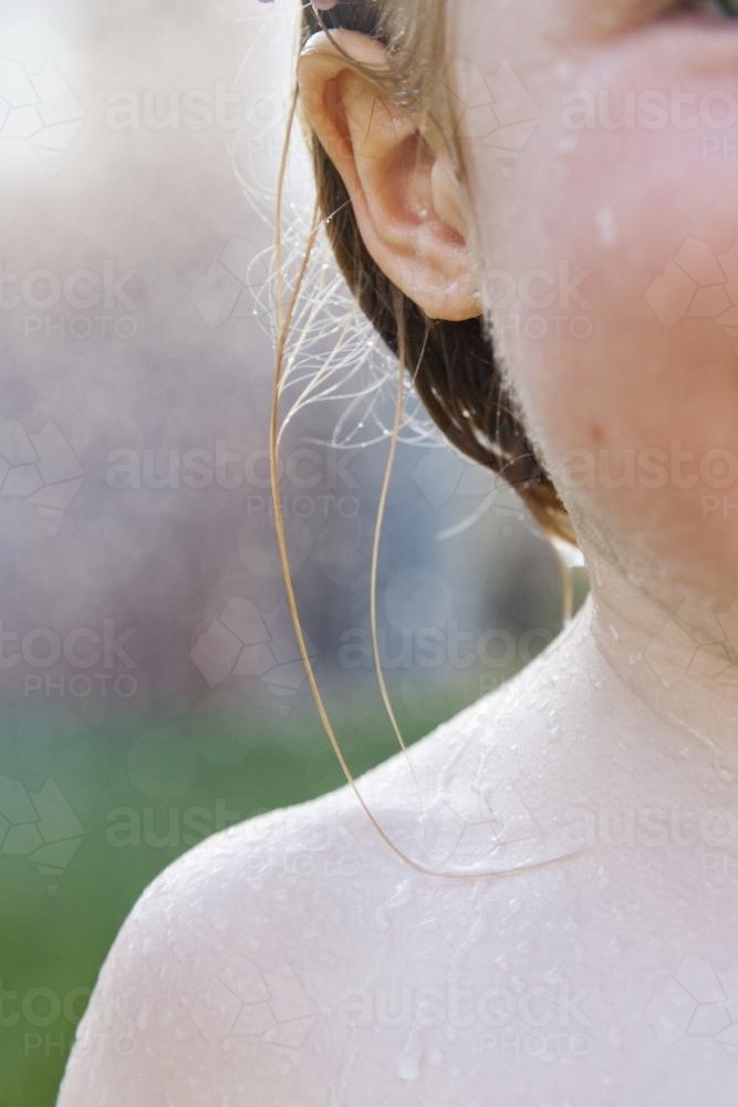 Close up of a young girls wet ear and shoulder - Australian Stock Image