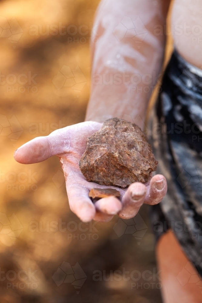 Close up of Aboriginal artefact held in hand axe head or cutting rock stone - Australian Stock Image