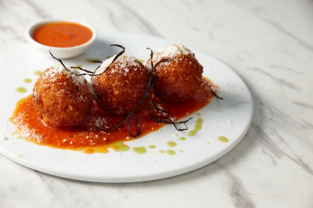 Close up of arancini balls on white plate - Australian Stock Image