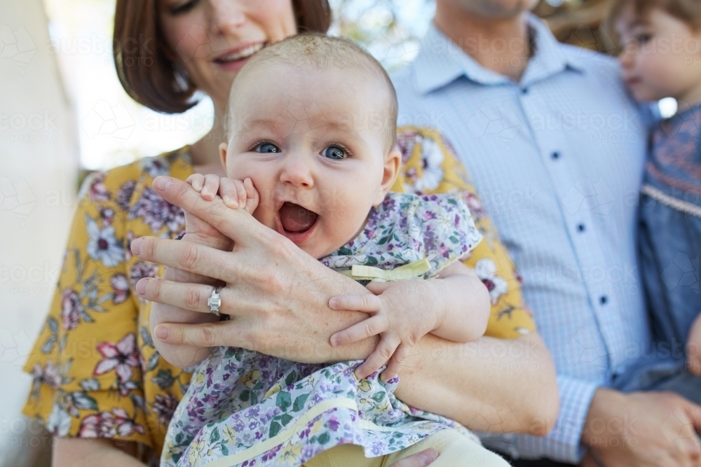 Close up of baby with family in background - Australian Stock Image