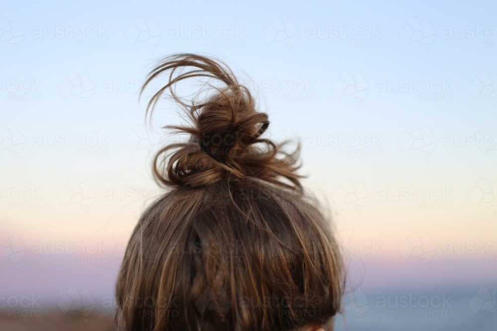 Close up of back of girls hair, pulled up in a bun - Australian Stock Image