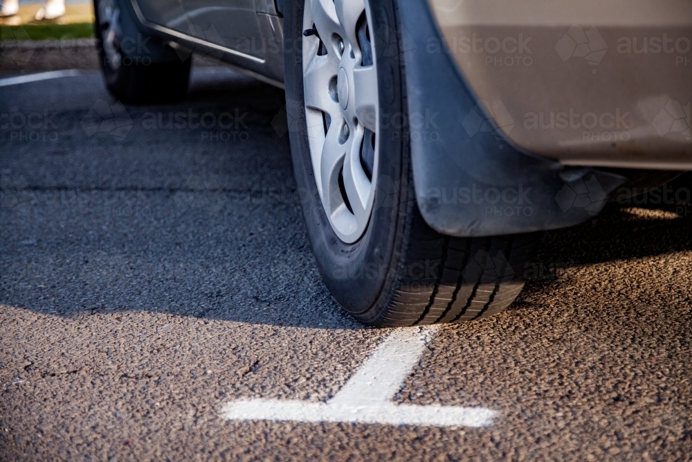 Close up of car parked across two spaces showing bad parking concept - Australian Stock Image