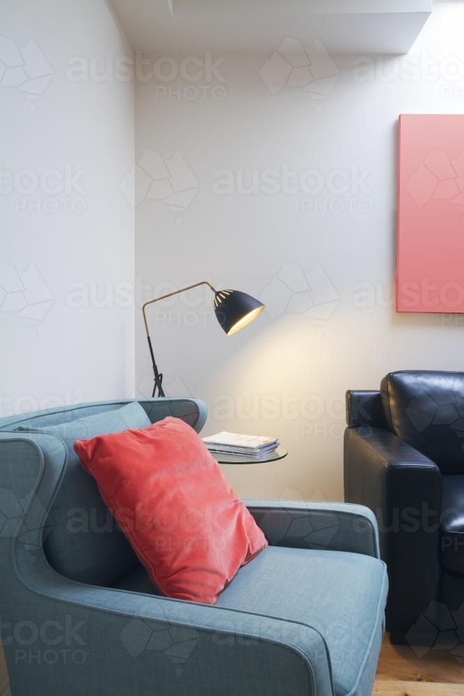 Close up of comfortable reading nook in contemporary home with lamp on side table - Australian Stock Image