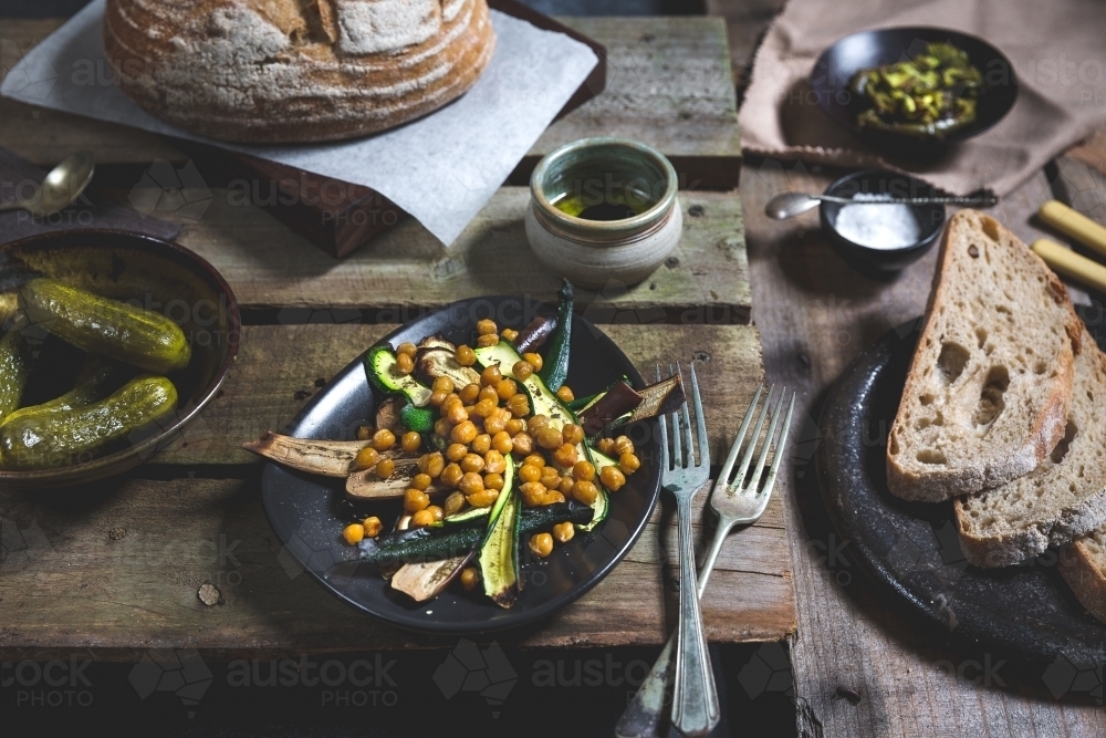 Close up of delicious antipasto meal of bread, pickles, roasted vegetables and chickpeas - Australian Stock Image