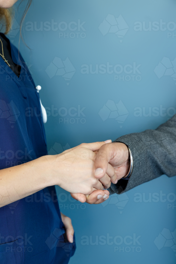 Close-up of doctor and nurse shaking hands - Australian Stock Image