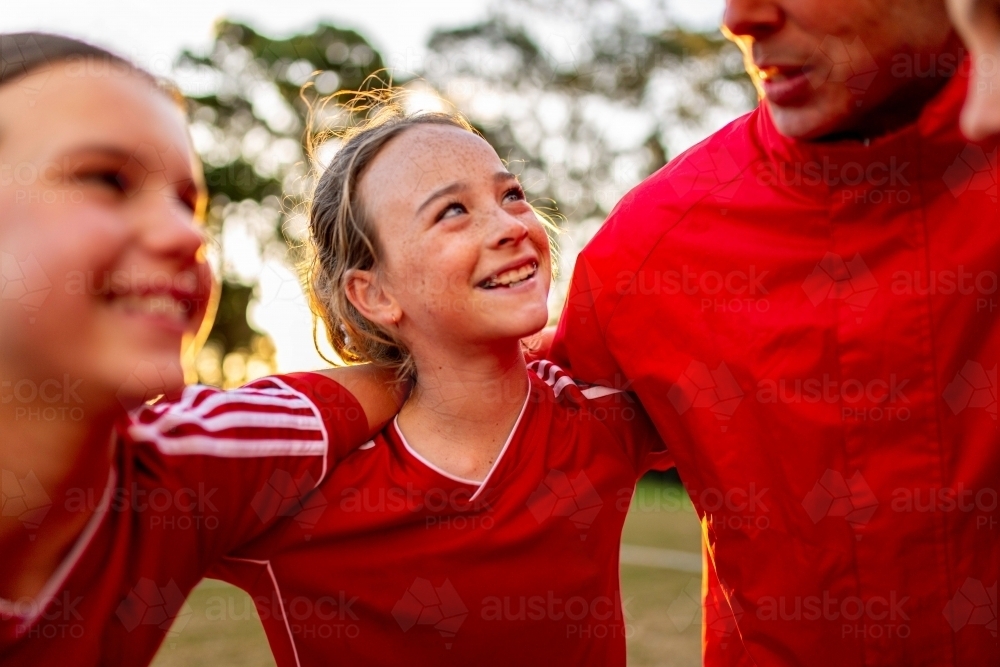 Close-up of female tween football team players in a huddle preparing for a game - Australian Stock Image