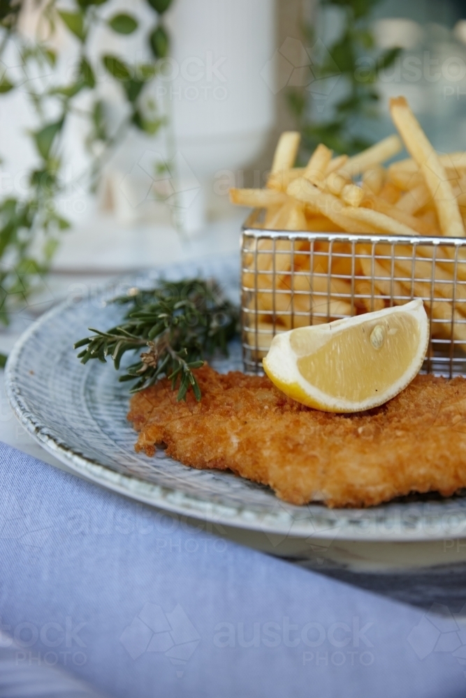 Close up of fish and chips with lemon slice on plate - Australian Stock Image