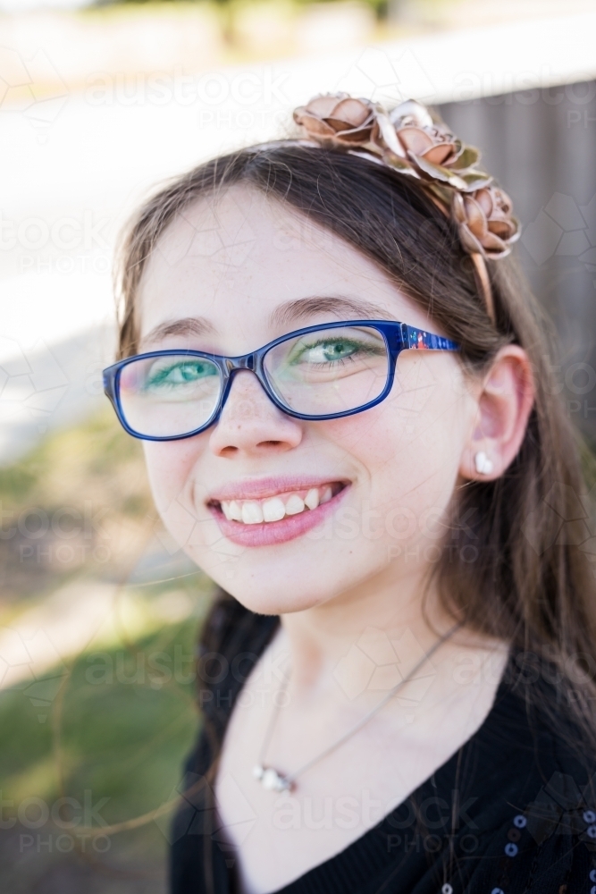 Close up of girl smiling wearing headband - Australian Stock Image