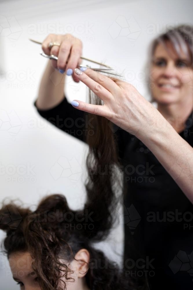 Close up of hairdresser cutting a young girl's hair - Australian Stock Image