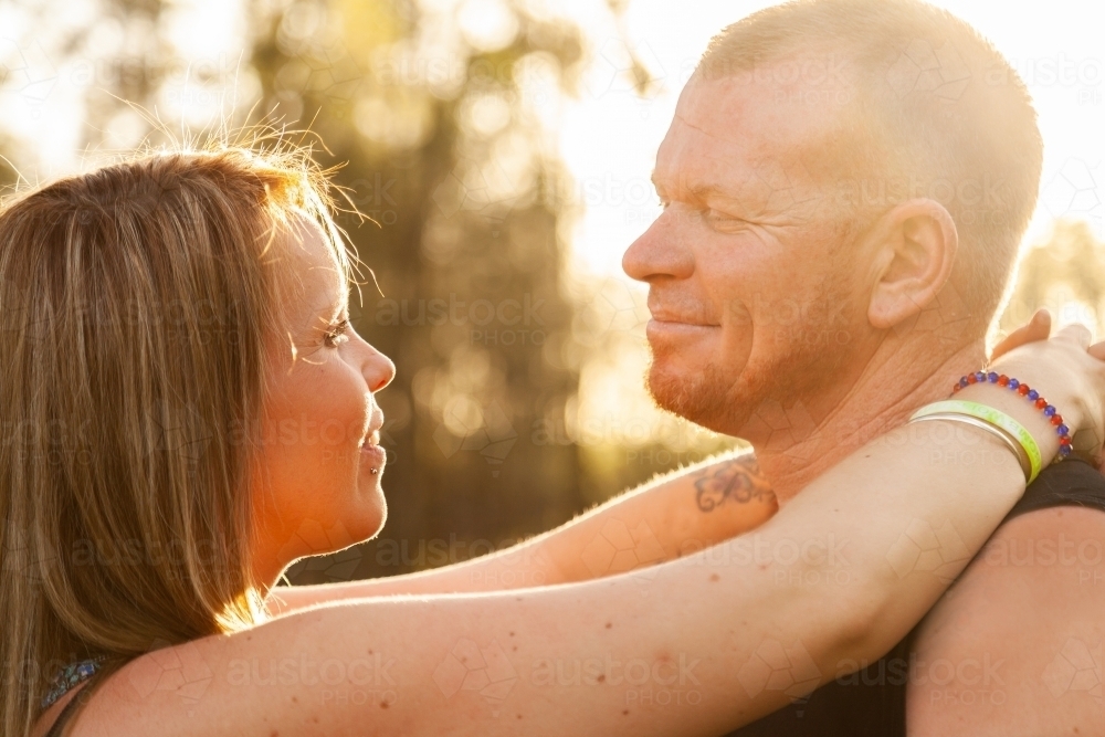 Close up of happy couple looking at one another in beautiful light - Australian Stock Image