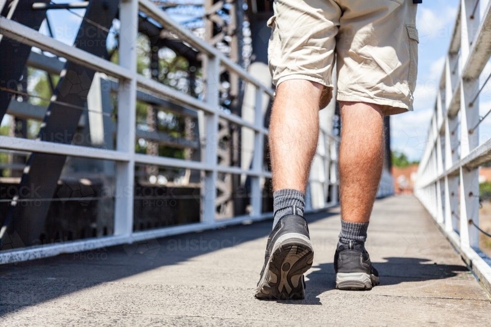Close up of joggers shoes walking over bridge - Australian Stock Image