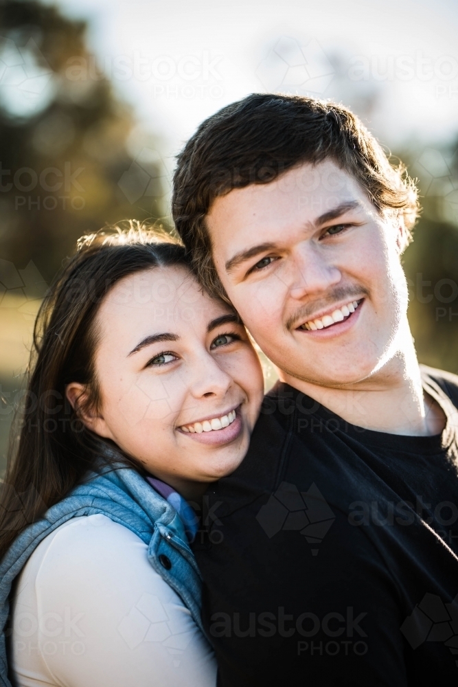 Close up of man and woman couple heads together smiling - Australian Stock Image