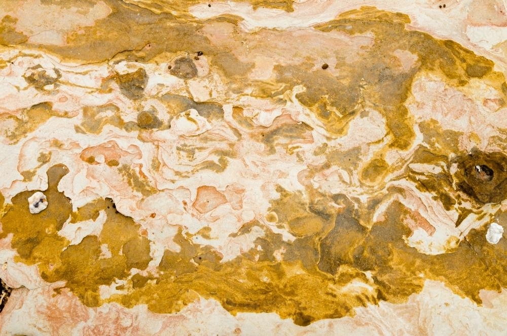 Close up of marbled rock with yellow colours - Australian Stock Image