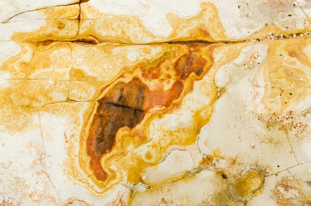 Close up of marbled rock with yellow colours - Australian Stock Image