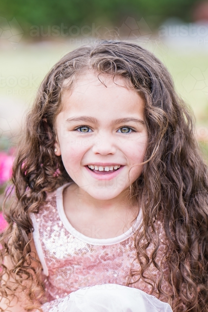 Close up of mixed race aboriginal caucasian girl smiling with curly hair - Australian Stock Image