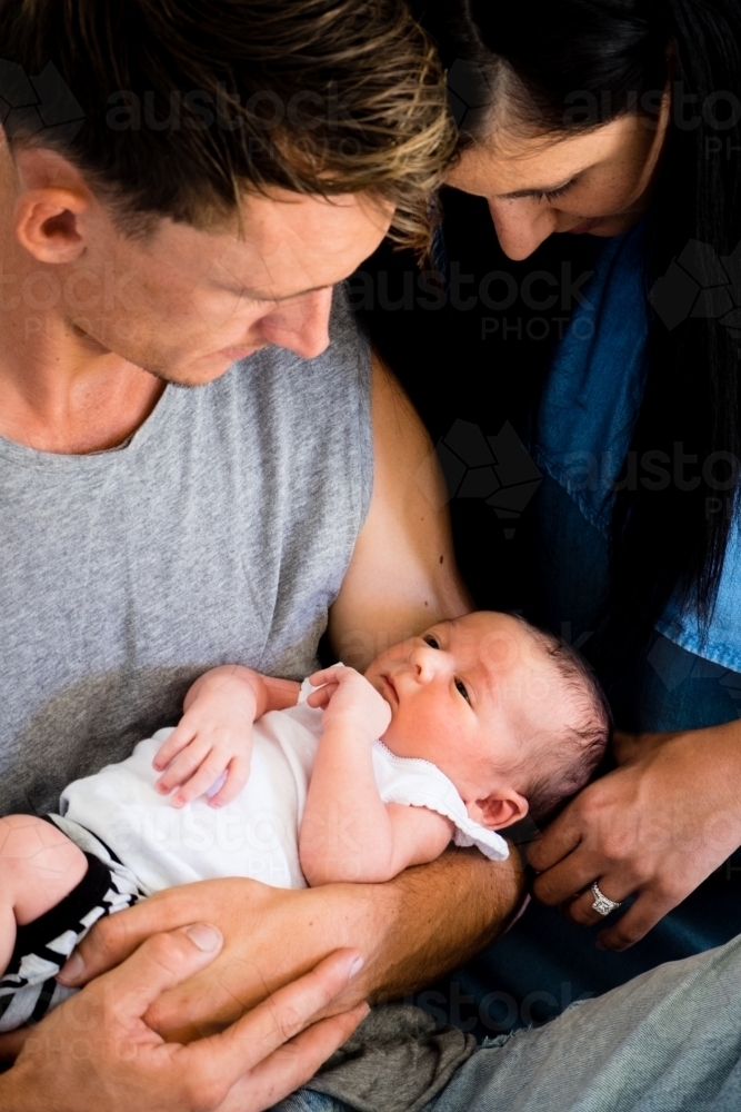 close-up of new born being held and looked at by mother and father - Australian Stock Image
