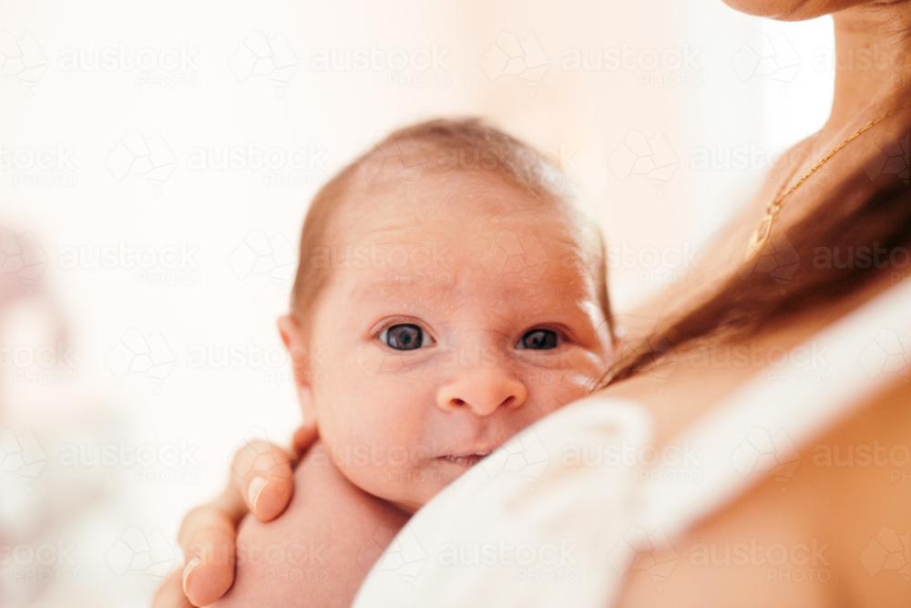 Close-up of Newborn baby girl resting on mother's chest - Australian Stock Image