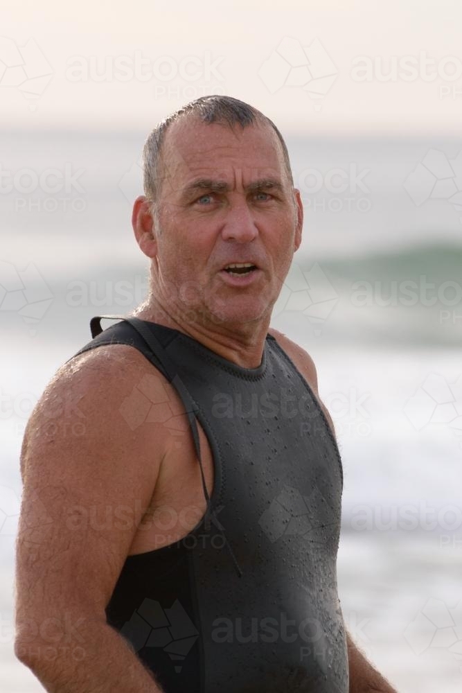 Close up of older man at beach in wetsuit - Australian Stock Image