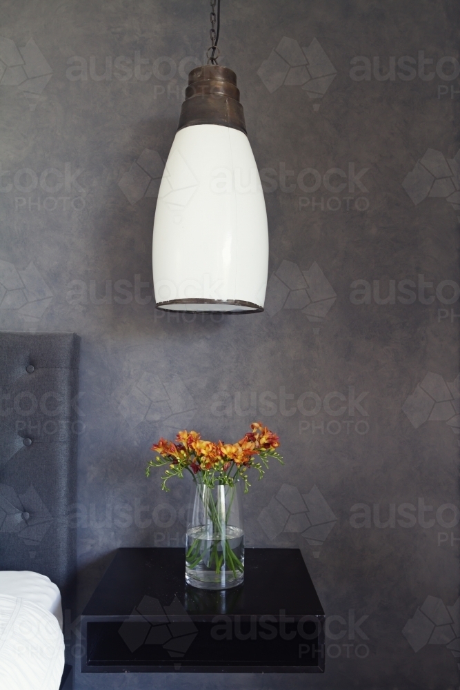 Close up of pendant light and flowers on bed side table - Australian Stock Image