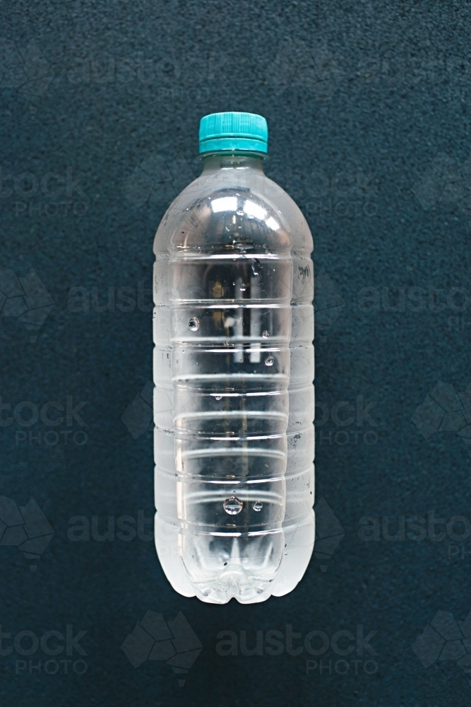 Close up of plastic water bottle on blue background - Australian Stock Image