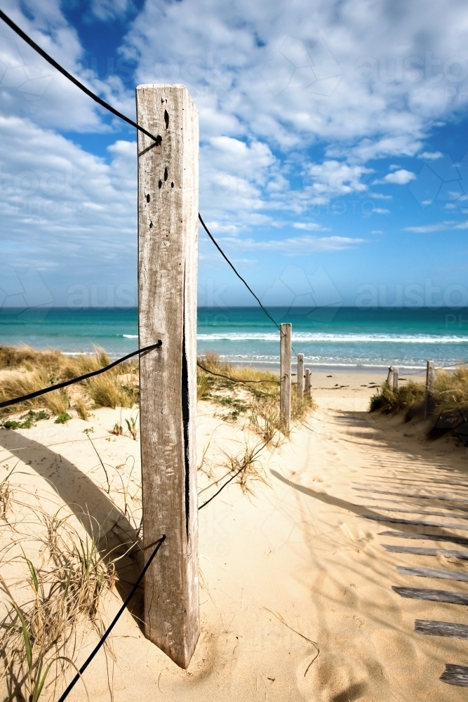 close up of post on board walk leading to a surf beach - Australian Stock Image