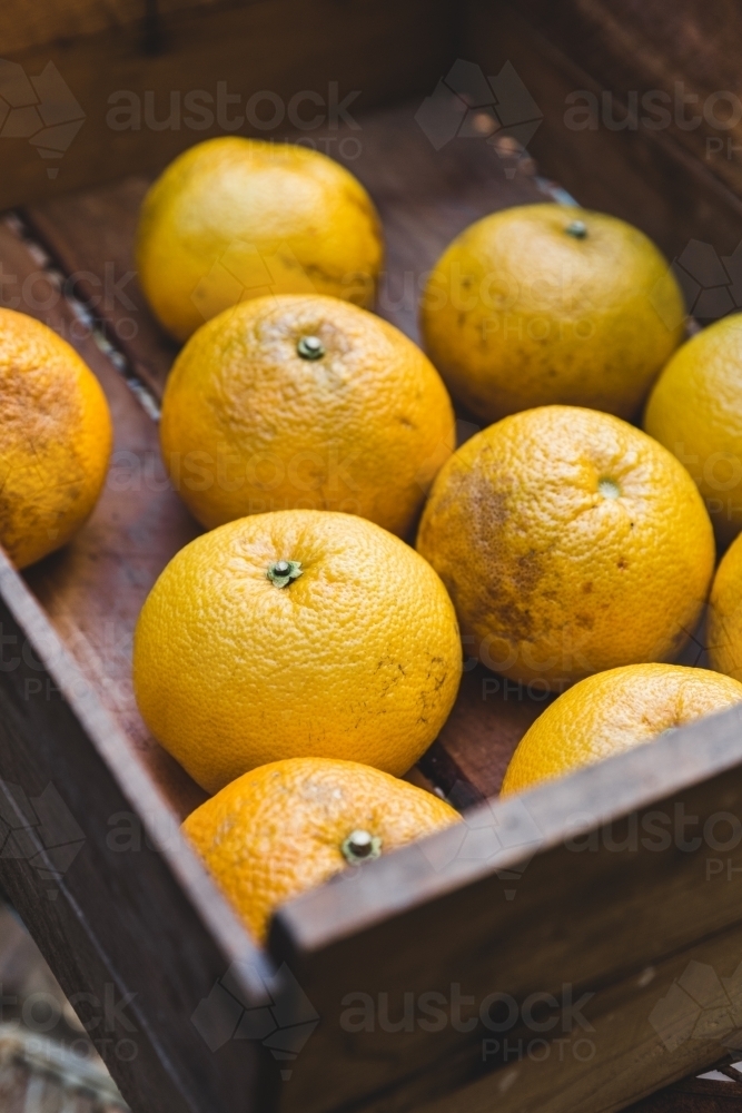 Close up of rustic timber box of orange citrus fruit - Australian Stock Image