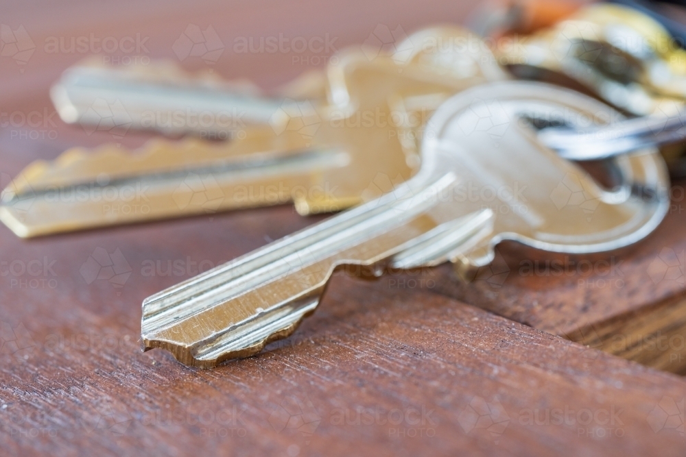 Close up of  silver keys lying on a table top - Australian Stock Image