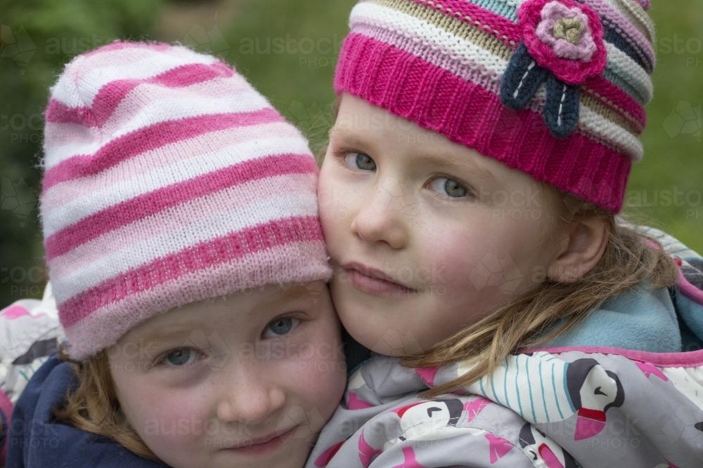 Close up of six year old twin sisters hugging - Australian Stock Image