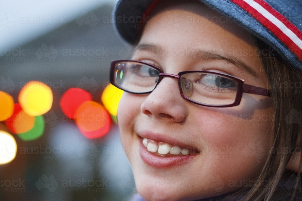 Close up of smiling girl with bokeh lights in the background - Australian Stock Image